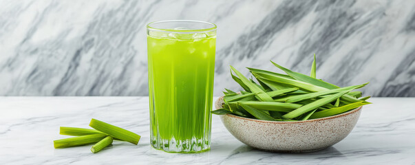 tall glass of vibrant green pandan drink sits next to fresh pandan leaves, showcasing refreshing and natural beverage. bright color and natural ingredients evoke sense of freshness and vitality