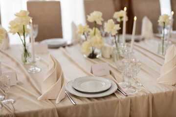 large beautiful banquet table in a restaurant with tablecloth and floral decor	
