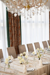 large beautiful banquet table in a restaurant with tablecloth and floral decor	
