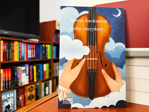 Illustrated book cover of Janko Muzykant by Henryk Sienkiewicz on a bookshelf