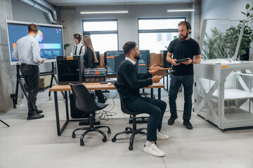 Conception of cooperation and communication. People are in the office by the 3d printer