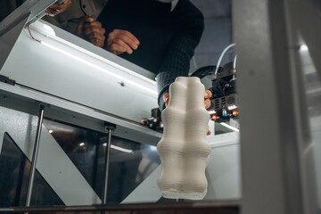 Focused view of printed object. People are in the office by the 3d printer