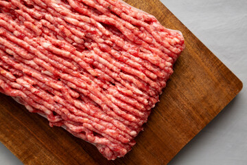 Organic Grass Fed Raw Chuck Ground Beef on a Wooden Board, top view. Close-up.