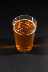 beer mug filled with foamy amber beer is positioned to the left on a black chalkboard background, leaving empty space on the right
