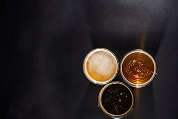 Three glasses of beer in the right left corner with empty space on the left, top view