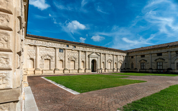The inner courtyard of Palazzo Te, an example of Mannerist architecture, features a central loggia with Doric columns supporting a classical entablature. Travel to Mantua, Italy.