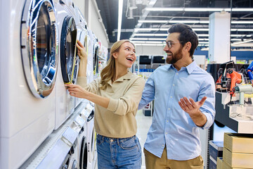 A couple is actively shopping for a washing machine in an electronics store today