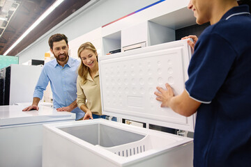 A couple is exploring freezer options with help from a knowledgeable sales associate