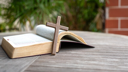 Wooden crucifix cross next to Holy Bible.