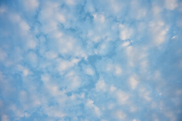 Beautiful blue sky dotted with small white clouds forming a relaxing and peaceful pattern