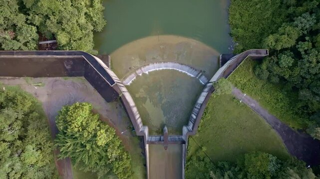 High-angle drone view of Hatillo Dam spillway, concrete structure, ideal for environmental, infrastructure, and hydroelectric themes. Aerial directly above