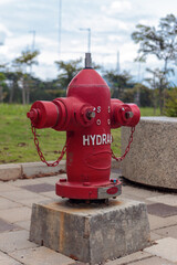 Red Fire Hydrant on Concrete Base in Outdoor Public Park