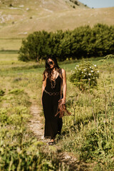 close up view of beautiful woman in black outfit holding necklace