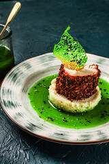 Chicken breast cooked sous vide in beetroot breading with couscous garnish and spinach sauce. Beautiful, restaurant-style presentation of the dish. Healthy food concept. Top view. Close-up