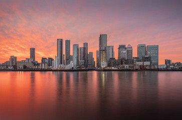 Fototapeta premium Canary Wharf shot from the Greenwich peninsula during a beautiful sunset and slack tide, creating a gorgeous image.