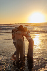 Friends hugging at sunset on the beach, enjoying precious moments together