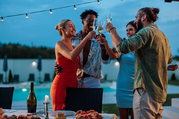 Friends toasting with champagne glasses at luxury pool party