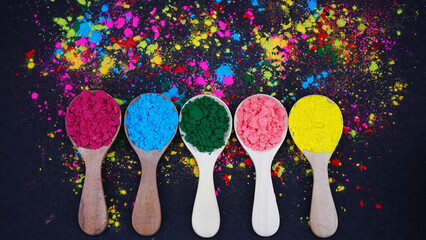 Holi Festival Colors Display with Wooden Spoons on a Vibrant Background