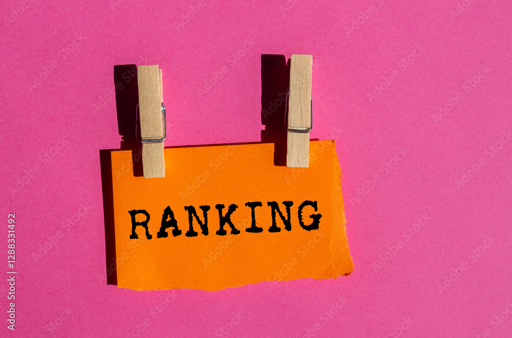 Wall mural Ranking message written on ripped torn orange paper on pink background. Conceptual ranking symbol. Copy space.