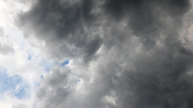 Time-lapse low angle footage of the dense gray clouds during daytime