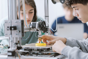 Students learning how to use a 3D printer in the lab