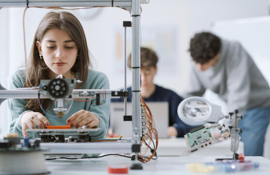 Female student using a 3D printer in the lab