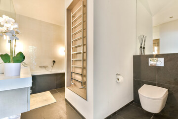 A stylish modern bathroom featuring sleek fixtures, a minimalist design, and elegant decor including orchids. bright lighting enhances the spacious feel.