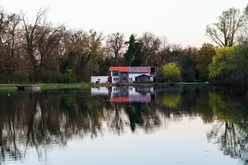Tranquil lakeside house reflection.