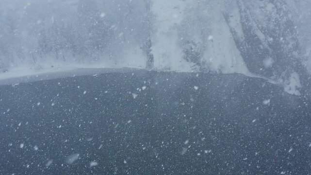 スーパースロー映像：ドローンで空撮した、大雪の日の川の上の風景