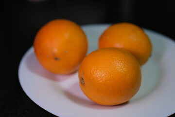 oranges on a white plate three pieces. High quality photo