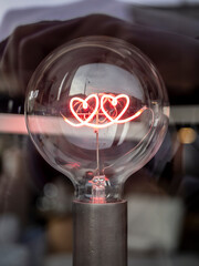A light bulb with a heart-shaped filament.
