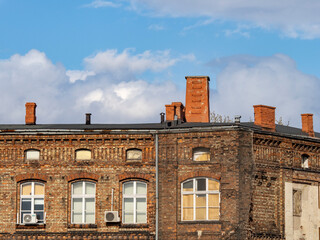 Historic Brick Building with Chimneys Under a Vibrant Sky
