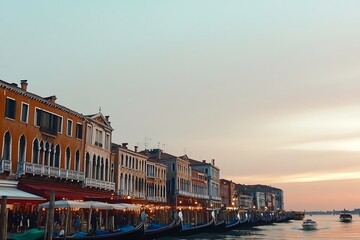 Obraz premium Gondolas line a Venice canal at sunset