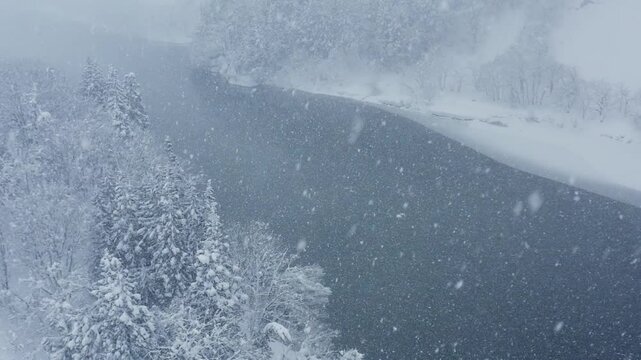 スーパースロー映像：ドローンで空撮した、大雪の日の川の上の風景