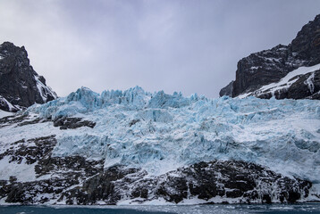 Glacier and snow covered rocks at Drygalski Fjord, South Georgia, South Atlantic