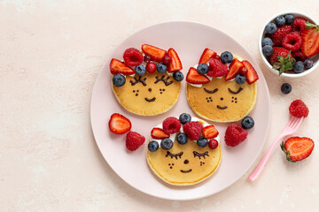 Cute smiling girl face  pancakes with fresh berries