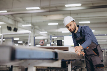 Factory male worker checking aluminum window frame on production line