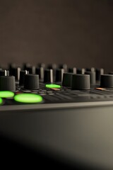 Close-up of sound mixer showcasing illuminated buttons and textu