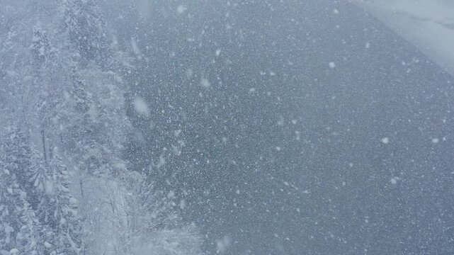 スーパースロー映像：ドローンで空撮した、大雪の日の川の上の風景