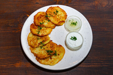 Crispy potato pancakes served with fresh herbs and dipping sauces