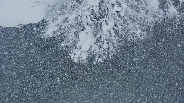スーパースロー映像：ドローンで空撮した、大雪の日の川の上の風景