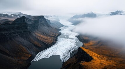 Weathering process concept. A breathtaking aerial view of a winding river surrounded by mountains and fog.
