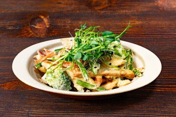 Fresh pasta dish with creamy sauce and greens served in a bowl