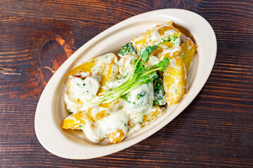 Delicious baked potatoes with cheese and broccoli in a dish
