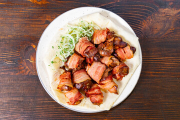 Bacon-wrapped chicken bites served with fresh vegetables on a plate
