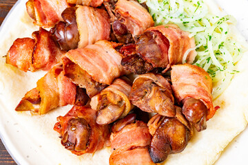 Savory bacon-wrapped delicacies served with fresh greens