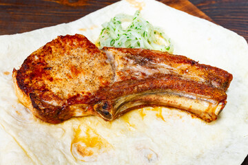 Baked pork rib on flatbread with fresh herbs and garnishes