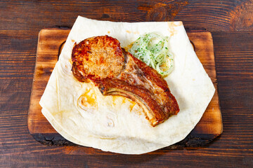 Baked pork rib served on flatbread with onions and herbs