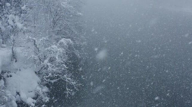スーパースロー映像：ドローンで空撮した、大雪の日の川の上の風景