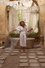 Fototapeta premium young slim woman dancing in the courtyard in the old city. A person standing in front of a building